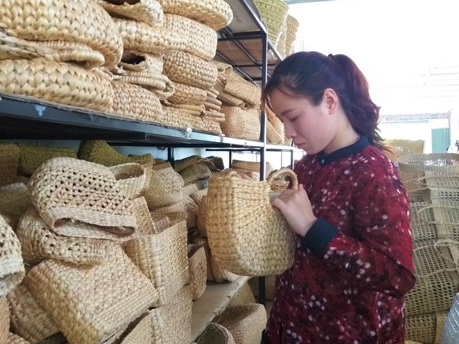 Những sợi lục bình được “hô biến” thành những chiếc túi xách thời trang qua bàn tay của cô gái trẻ – Ảnh: Kim Hà.